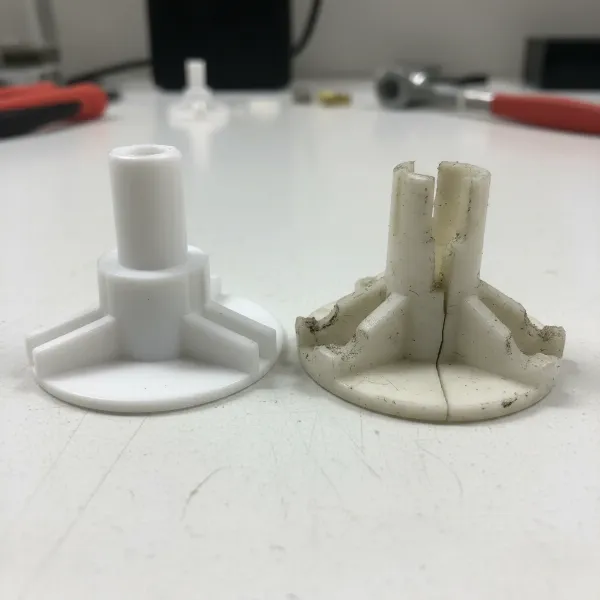 Close-up of a damaged or worn microwave turntable coupler, showing stripped splines.