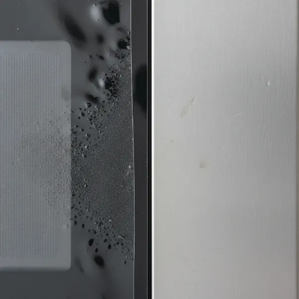 Close-up of fingerprint-resistant stainless steel microwave surface showing a protective coating