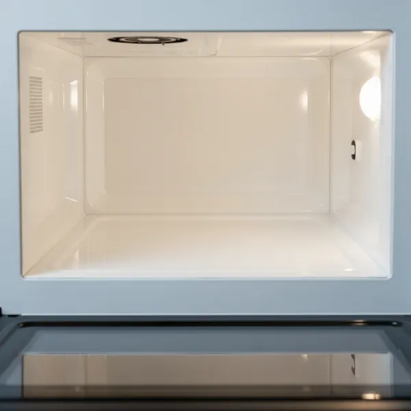A clean, empty flatbed microwave interior with a smooth, ceramic base ready for use.