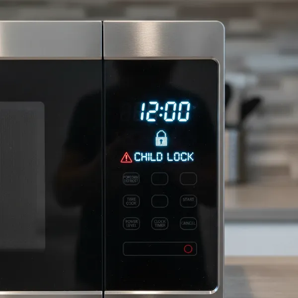 Microwave display showing a child lock activated, with a warning symbol.