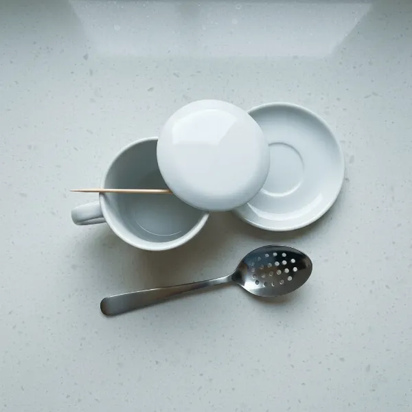 Essential equipment for microwave egg poaching: mug, plate, toothpick, and slotted spoon.