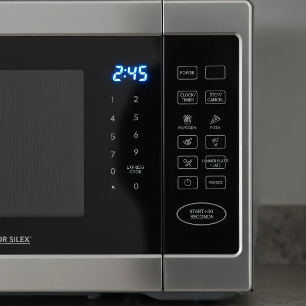 Close-up of Proctor Silex digital microwave control panel with LED display and buttons.